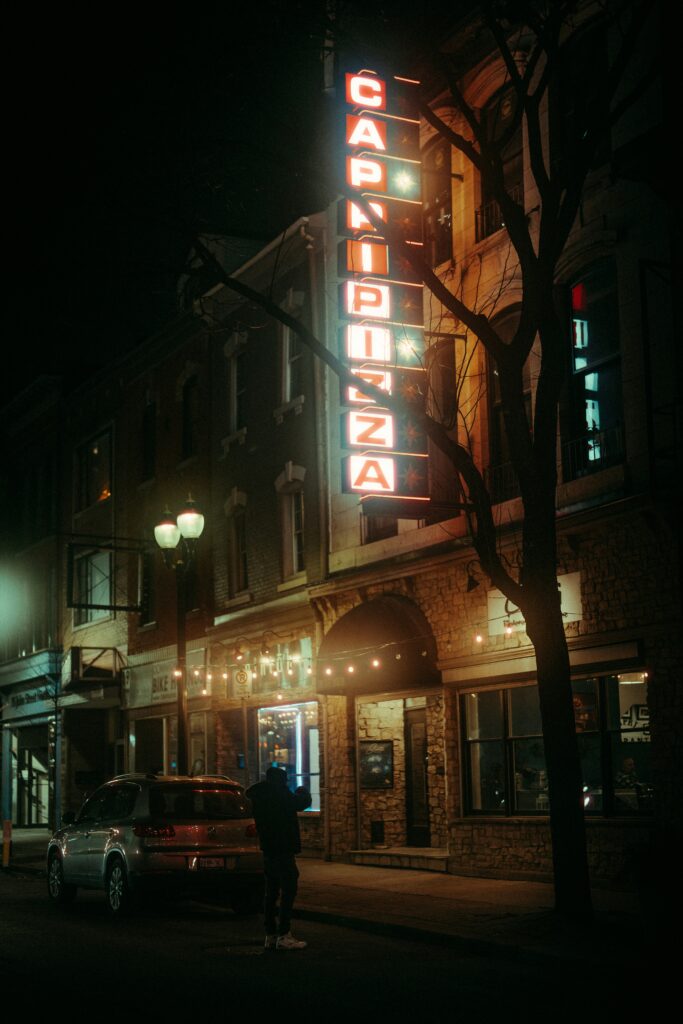 a person standing on the sidewalk in front of a building